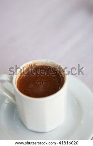 Small white cup of turkish coffee as served in a small rural cafe in Turkey. Very Shallow Depth of Field