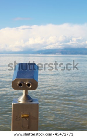 A metallic coin operated viewer for tourists to look at the Greek Islands over the Aegean from the Turkish harbor in Kusadasi on a sunny day