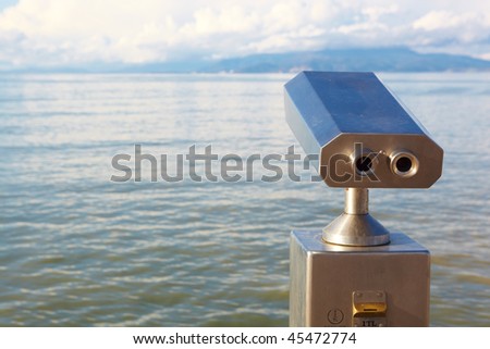 A metallic coin operated viewer for tourists to look at the Greek Islands over the Aegean from the Turkish harbor in Kusadasi on a sunny day