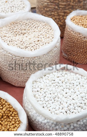 Chickpeas and Garbanzo beans in bags of dry produce (nuts, seeds and spices) from the market as a textured food background. Shallow DOF, focus on lower third.
