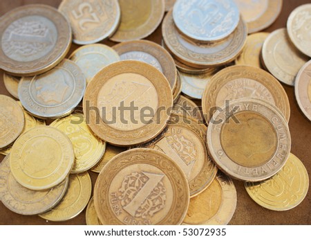 A Small heap of turkish coins on a smooth brown leather sheet