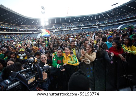 SOWETO - JUNE 10: Fans interviewed for TV while watching international performers at Orlando Stadium for the FIFA World Cup Kick Off Celebration Concert on June 10, 2010 in Soweto.