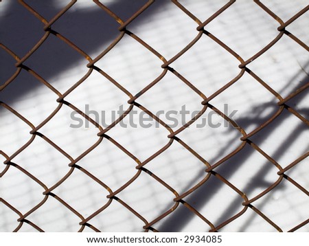 Rusty woven wire fence against snow background