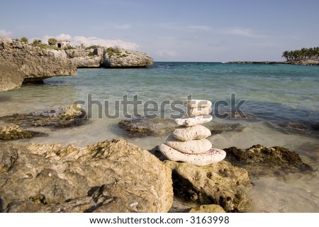 Rocky sea shore of Riviera Maya with stack of balancing rocks.