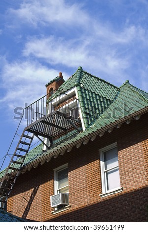Green roof with Mediterranean tiles against blue sky