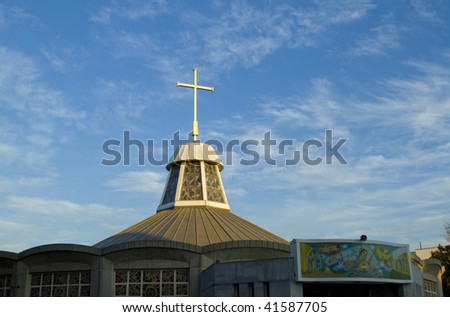 Golden cross on the top of the Church of St. Mary, Mother of Jesus Roman Catholic church