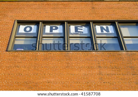 Open sign in the windows on the brick wall