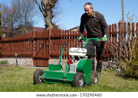 Spring work in garden. Man work with Man working with Lawn Aerator