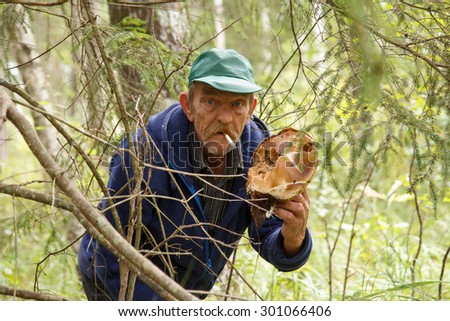 An old man with a boletus in his hands and a smoke in his mouth