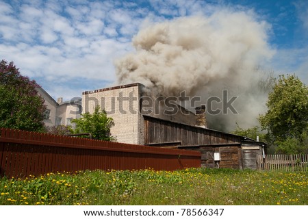 fire in city building, with white smoke to the blue sky
