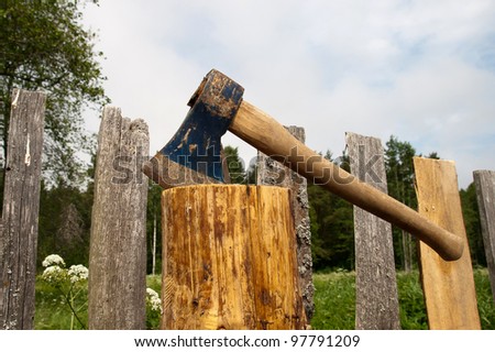 Axe in log after an old wooden fence repair