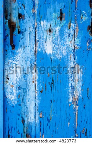 Close up of old wooden door with blue peeling paint