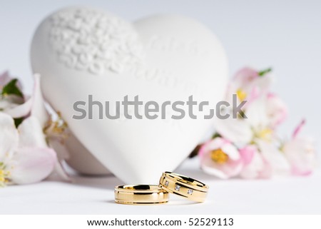 stock photo two wedding rings with flowers and a heart in the background