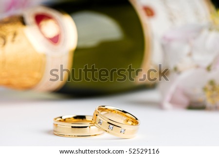 stock photo two wedding rings with flowers and a champagne bottle in the