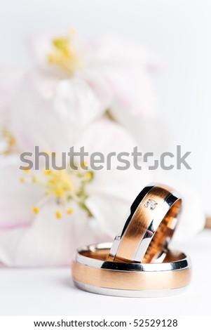stock photo two wedding rings with flowers in the background