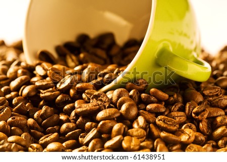 green cup of coffee with brown beans