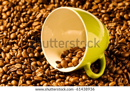 green cup of coffee with brown beans