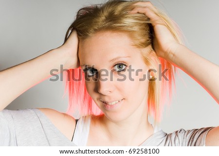 young woman with red and blonde hair with hands on head