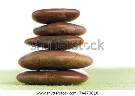 brown flat stones in balance on green sand