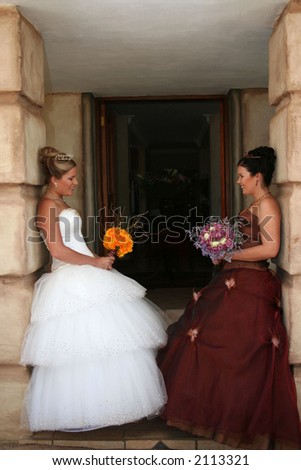 Young bride in white wedding dress with brides maid waiting at door