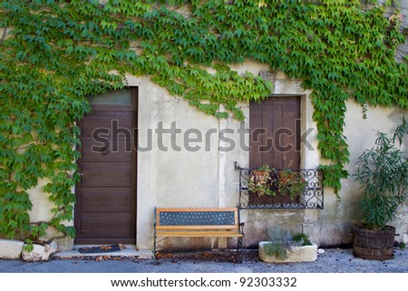 Provence, France: House covered by vegetation and a bench