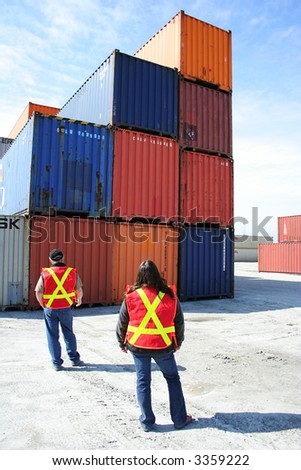 Two People standing and watch the containers
