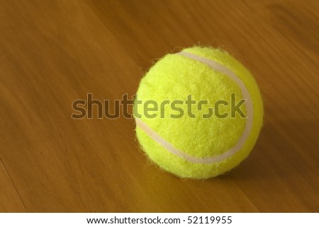 Yellow tennis ball on wood table