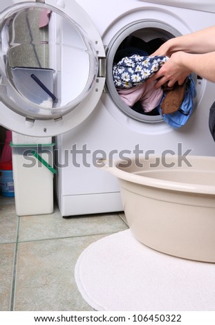 woman loading Preparation washing machine in bathroom clothes in the washing machine