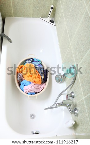 Pile of dirty laundry in bath washing machine green bathroom