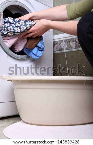 woman loading Preparation washing machine in bathroom clothes in the washing machine