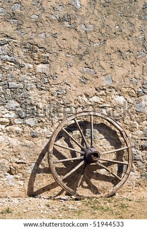 wheel at a brickwall wagon stone wall.