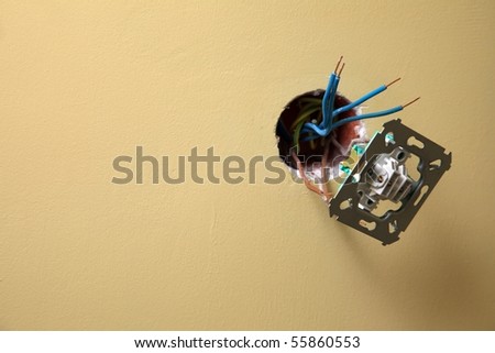 electrician installing a power socket wall background, Dirty socket hanging out of the wall