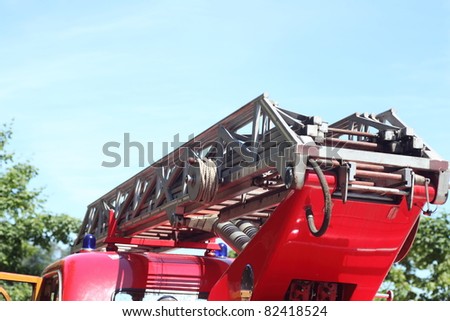 Ladder of a fire truck on the blue sky, emergency light on firetruck