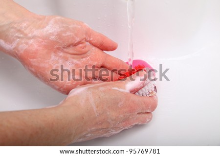 Woman wash red soapy hands in bathroom soap nail brush person scrubbing nails