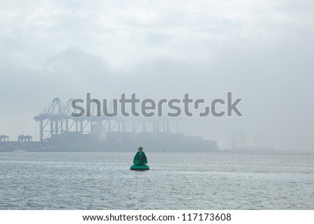 A UK container port shrouded in sea fog - logos removed