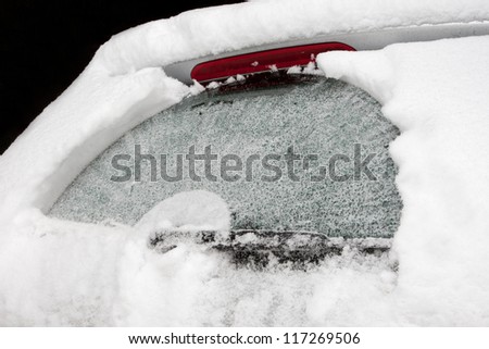 The rear screen of a car covered with ice and snow