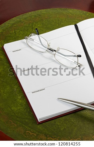 Diary page with pen and glasses. Dates removed.