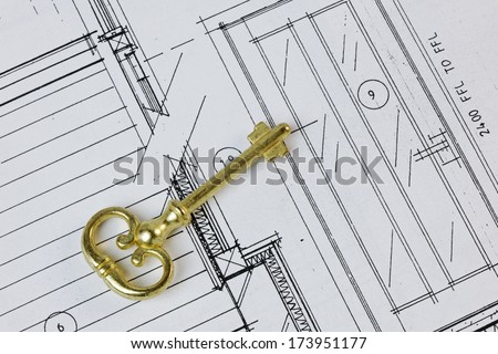 An antique key on a house plan. Ownership/design concept