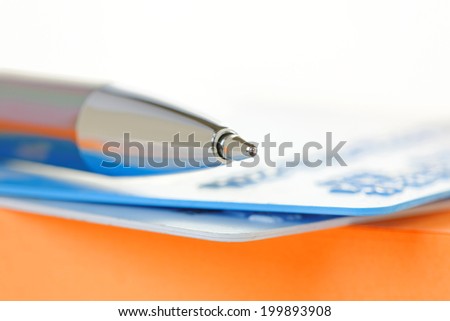 Pen and credit cards on a note pad. Shallow depth of field