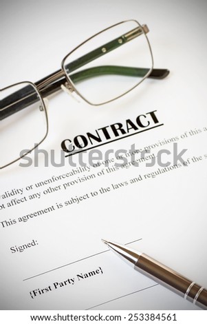 Close up of a contract ready to be signed.With pen and glasses.Office,legal concept.With vignette
