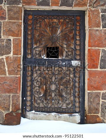 Old door with metal grill locked with a chain