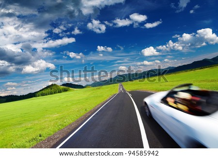 Mountain landscape with road and moving car