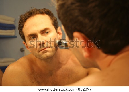 Man shaving with electric shaver.