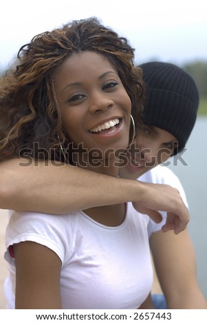 Happy young interracial couple looking into camera