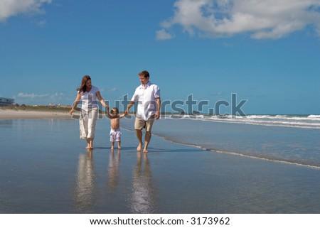 Happy family walking on a beach
