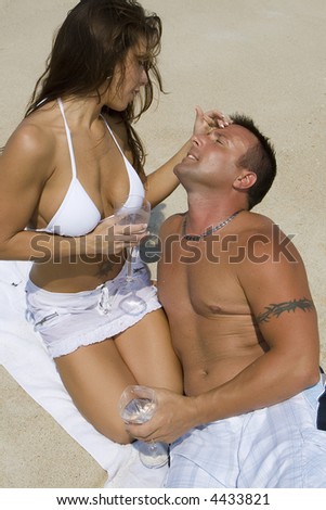 Couple enjoying the beach, sun and sand.  Blue sky in the background