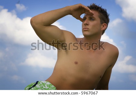 Shirtless man looking ahead, blue sky in the background