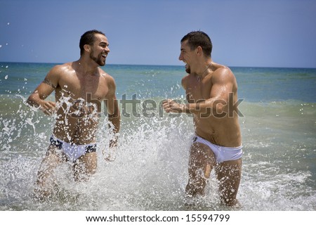 Two man at the beach running in the ocean