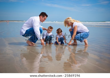 Family on a beach looking at findings in the sand