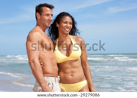 Well build couple standing at the beach, having fun